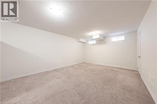 Basement featuring a textured ceiling and light carpet - 391 Athabasca Common, Oakville, ON - Indoor