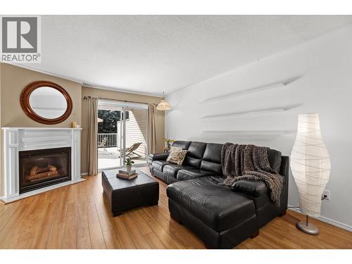 Natural light pours in through the glass door next to a cozy fireplace! - 4404 Pleasant Valley Road Unit# 6, Vernon, BC - Indoor Photo Showing Living Room With Fireplace