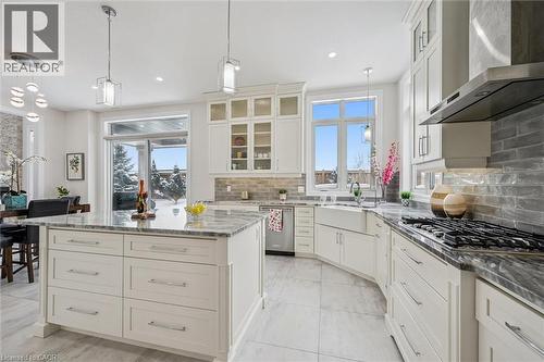 Kitchen featuring glass insert cabinets, dark stone countertops, wall chimney exhaust hood, pendant lighting, and recessed lighting - 263 Chestnut Ridge, Waterloo, ON - Indoor Photo Showing Kitchen With Upgraded Kitchen