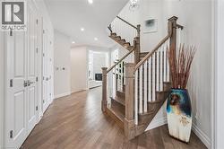 Staircase with wood-type flooring, recessed lighting, and a glass covered fireplace - 