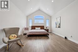 Bedroom featuring lofted ceiling and wood finished floors - 