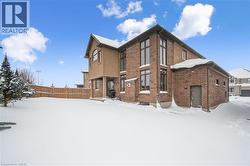 Snow covered house featuring brick siding - 