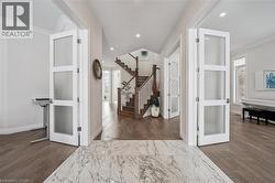Foyer featuring dark wood-type flooring, french doors, recessed lighting, and stairs - 