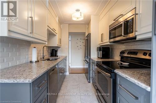 Kitchen featuring tasteful backsplash - 402 - 40 Harrisford Street, Hamilton, ON - Indoor Photo Showing Kitchen