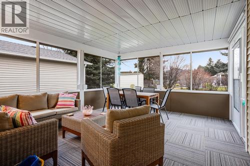 Screened patio with metal security shutters, perfect for enjoying outdoor space in comfort. - 1255 Raymer Avenue Unit# 507, Kelowna, BC - Outdoor With Deck Patio Veranda With Exterior