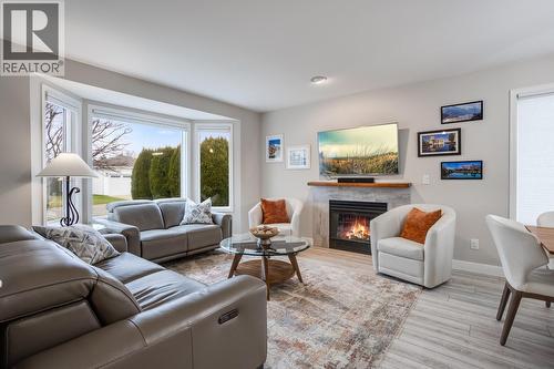 Spacious, sun-filled living room with updated flooring and a comfortable open layout. - 1255 Raymer Avenue Unit# 507, Kelowna, BC - Indoor Photo Showing Living Room With Fireplace