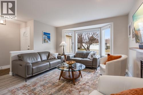 Bright, spacious living room featuring a cozy fireplace, large windows, and updated flooring, creating a warm and inviting space. - 1255 Raymer Avenue Unit# 507, Kelowna, BC - Indoor Photo Showing Living Room