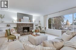 Bright, open living area with large windows framing stunning lake and city views. - 