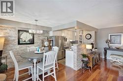 Dining room with a chandelier, wood finished floors, and a textured ceiling - 