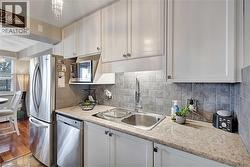 Kitchen featuring white cabinetry, stainless steel appliances, and a chandelier - 