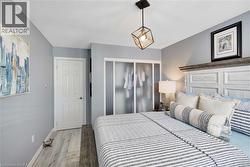 Bedroom with wood finished floors, a closet, and a textured ceiling - 