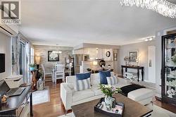 Living room featuring a chandelier, a wall mounted air conditioner, wood finished floors, and a textured ceiling - 