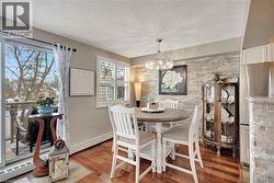 Dining area featuring a textured ceiling, wood finished floors, a chandelier, and a baseboard heating unit - 
