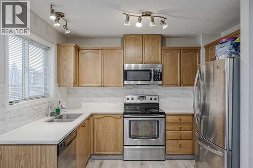 222 Bridleridge Way Sw, Calgary, AB - Indoor Photo Showing Kitchen With Double Sink With Upgraded Kitchen