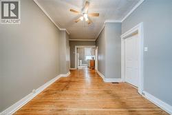 Hall with crown molding and light wood finished floors - 