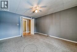 Carpeted empty room with a drop ceiling and baseboards - 