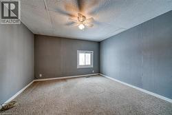 Spare room with a drop ceiling, light colored carpet, and ceiling fan - 