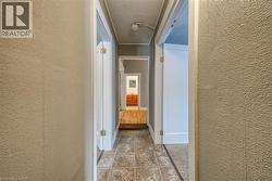 Hallway featuring a textured wall and baseboards - 