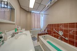 Full bath with a paneled ceiling, a bath, radiator, and vanity - 