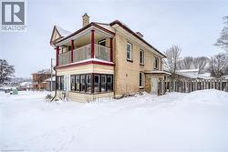 View of snowy exterior with a chimney, a sunroom, and a balcony - 