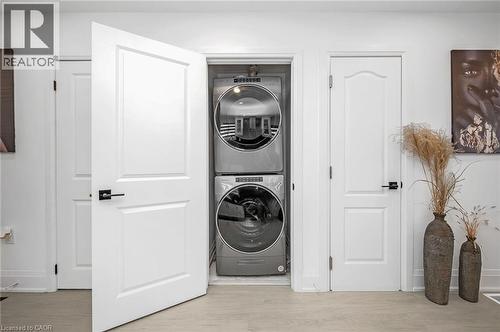 Laundry room featuring stacked washer / dryer and light wood-style flooring - 525 Britannia Avenue, Hamilton, ON - Indoor Photo Showing Laundry Room