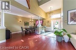 Entryway featuring dark wood-style floors, a chandelier, and decorative columns - 