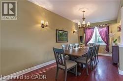 Dining room featuring a chandelier and dark wood-style floors - 