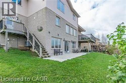 Back of house featuring a patio area, a lawn, stairway, and stucco siding - 158 River Run Road, Drayton, ON - Outdoor With Deck Patio Veranda