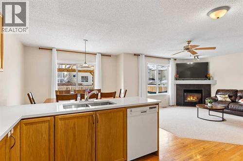 176 Cougar Ridge Circle Sw, Calgary, AB - Indoor Photo Showing Kitchen With Fireplace With Double Sink
