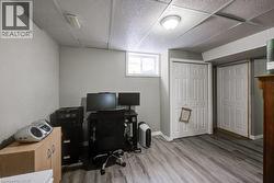 Office space with light wood finished floors and a drop ceiling - 