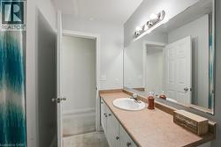Bathroom with vanity and light carpet - 