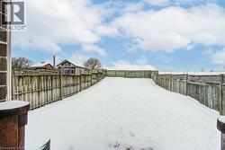 Yard covered in snow featuring a fenced backyard - 