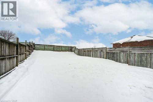 Yard layered in snow with a fenced backyard - 711 Southwood Way, Woodstock, ON - Outdoor