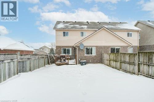 Snow covered property featuring a fenced backyard, brick siding, and a deck - 711 Southwood Way, Woodstock, ON - Outdoor