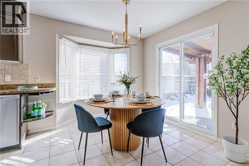Dining area with light tile patterned flooring and a chandelier - 15 Claudette Gate, Hamilton, ON - Indoor Photo Showing Dining Room