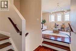 Staircase with hardwood / wood-style flooring and a chandelier - 