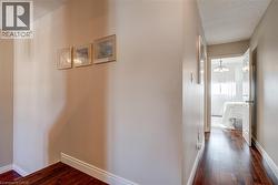 Hall featuring a textured ceiling, dark wood-type flooring, and a chandelier - 