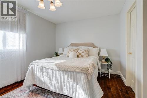 Bedroom with dark wood finished floors and a chandelier - 15 Claudette Gate, Hamilton, ON - Indoor Photo Showing Bedroom
