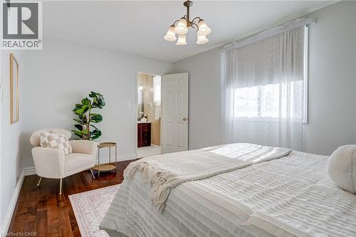 Bedroom with dark wood-style floors and a chandelier - 15 Claudette Gate, Hamilton, ON - Indoor Photo Showing Bedroom