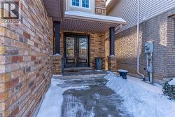 Snow covered property entrance with french doors and brick siding - 