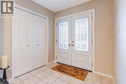 Foyer with french doors and light tile patterned flooring - 15 Claudette Gate, Hamilton, ON - Indoor Photo Showing Other Room