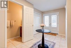 Entrance foyer featuring light tile patterned flooring and french doors - 
