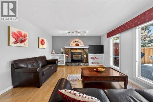 family room - 137 Woodbrook Road Sw, Calgary, AB - Indoor Photo Showing Living Room With Fireplace