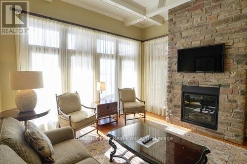 Living Room with Fireplace & Overlooks Lake - C2 5C - 1003 Matthews Drive, Muskoka Lakes (Watt), ON - Indoor Photo Showing Living Room With Fireplace