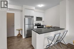 Kitchen featuring appliances with stainless steel finishes, white cabinets, a breakfast bar area, and a peninsula - 