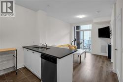 Kitchen with a peninsula, dishwasher, and white cabinetry - 