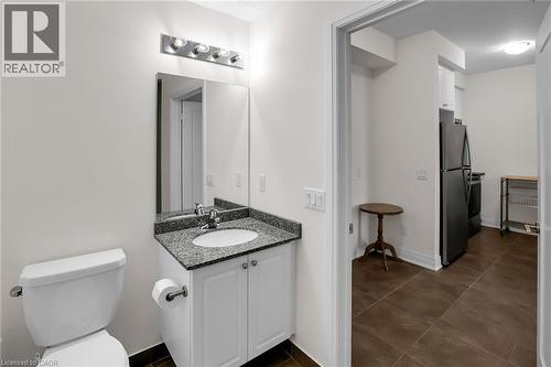 Half bathroom with vanity and dark tile patterned flooring - 16 Concord Place Unit# 431, Grimsby, ON - Indoor Photo Showing Bathroom