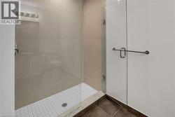 Bathroom featuring a stall shower and dark tile patterned flooring - 