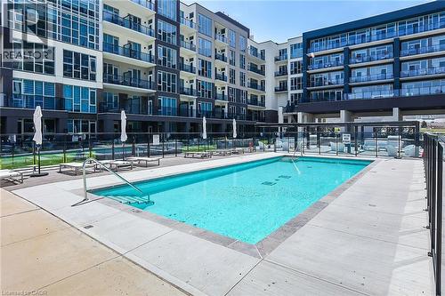 Community pool featuring a patio - 16 Concord Place Unit# 431, Grimsby, ON - Outdoor With In Ground Pool With Facade