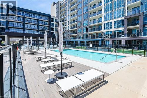 Community pool with a patio area - 16 Concord Place Unit# 431, Grimsby, ON - Outdoor With In Ground Pool With Balcony With Facade